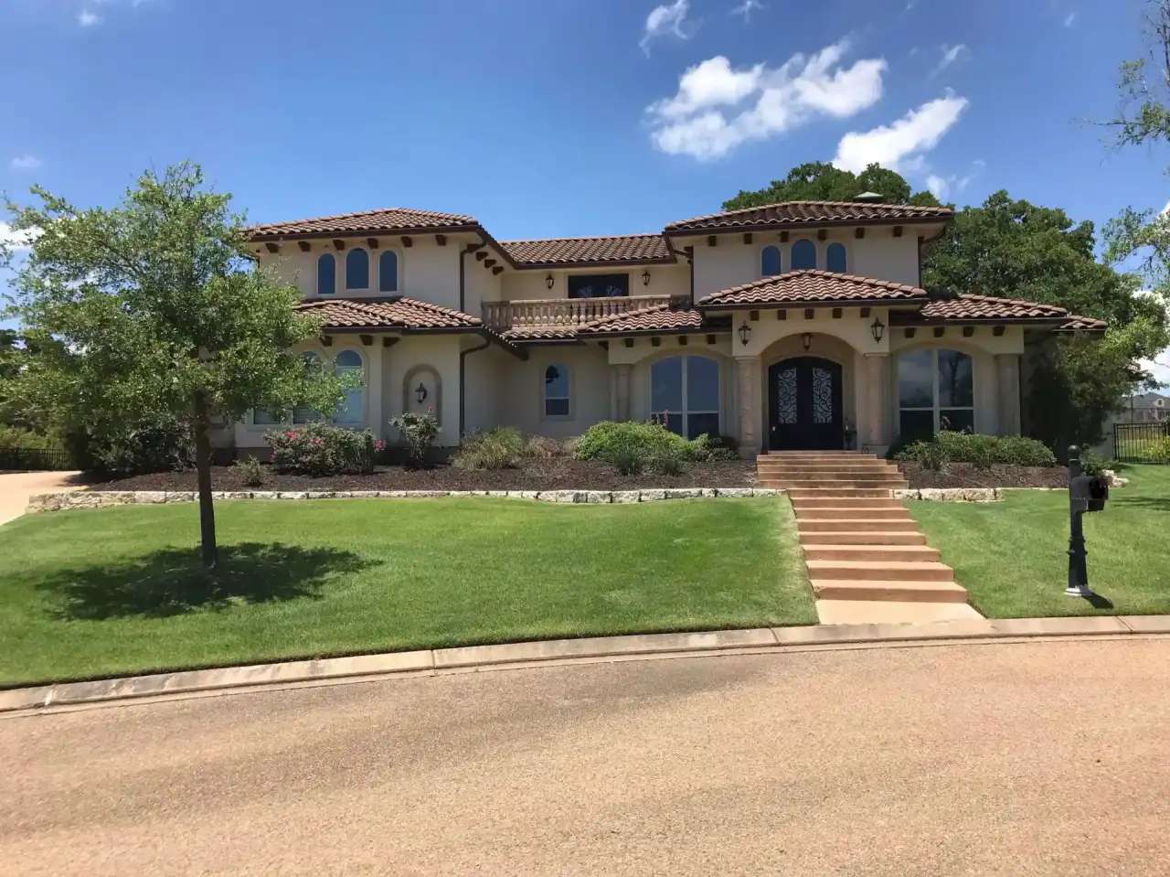 Freshly mowed lawn at large Mediterranean-style home in College Station