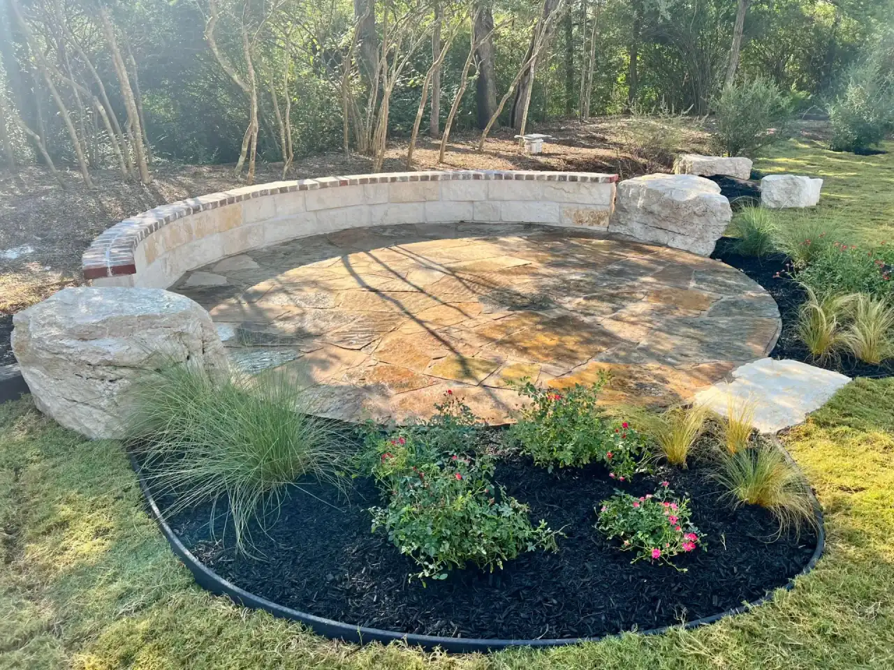 Curved stacked stone wall wrapping a round flagstone patio