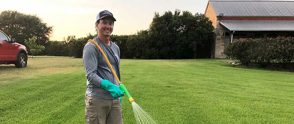 Greener LawnScapes company owner spraying a Brazos Valley, TX lawn with fungicide.