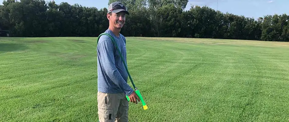 A Greener LawnScapes lawn care worker applying weed control treatments in Brazos Valley, TX.