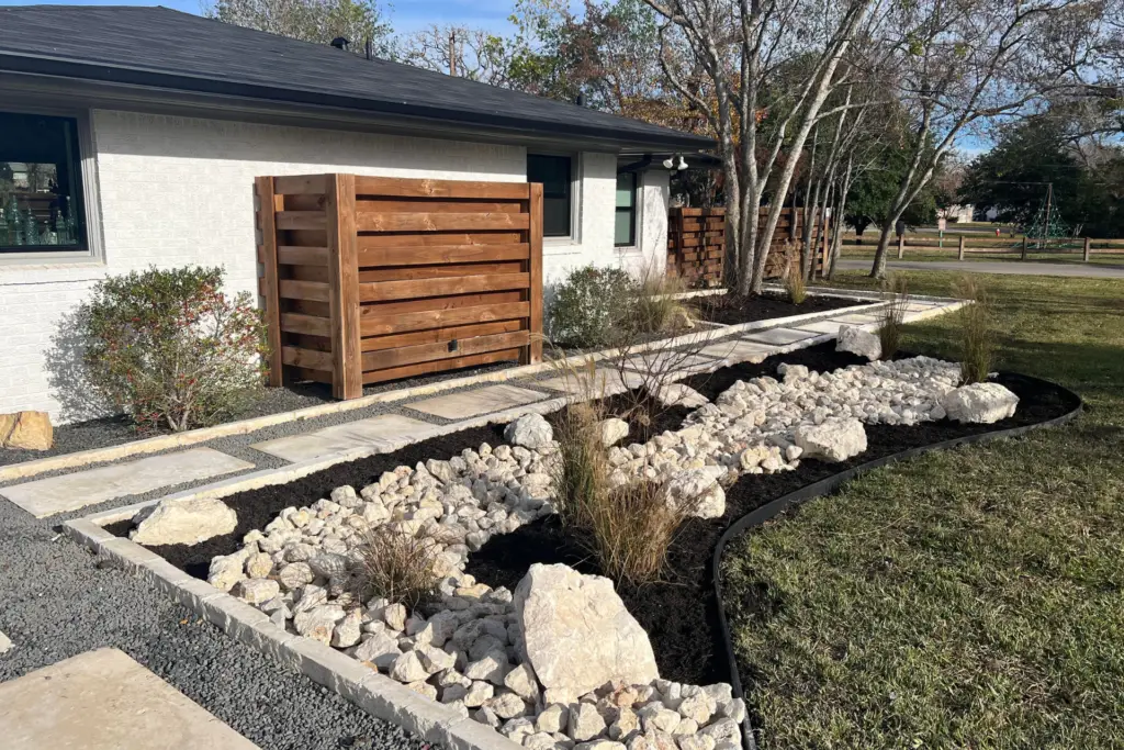 Brazos Valley landscape bed showing the kind of material choice tradeoff this article compares for cost maintenance and plant health