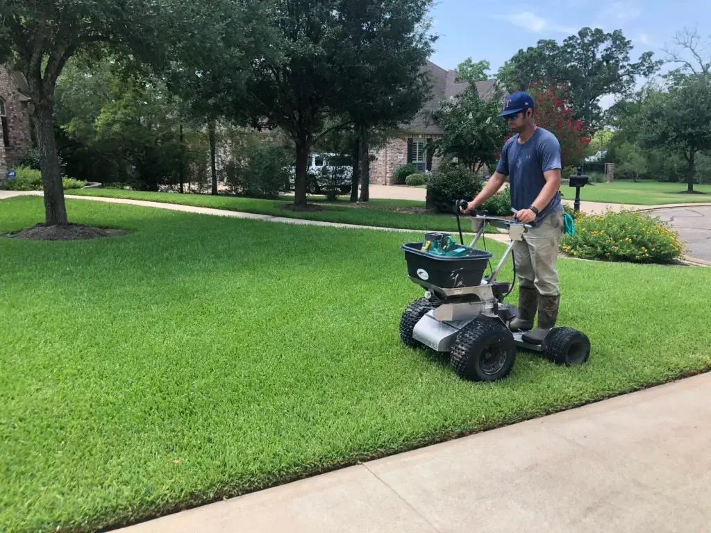 Greener LawnScapes crew performing a professional landscape service treatment on a finished residential property in Bryan/College Station